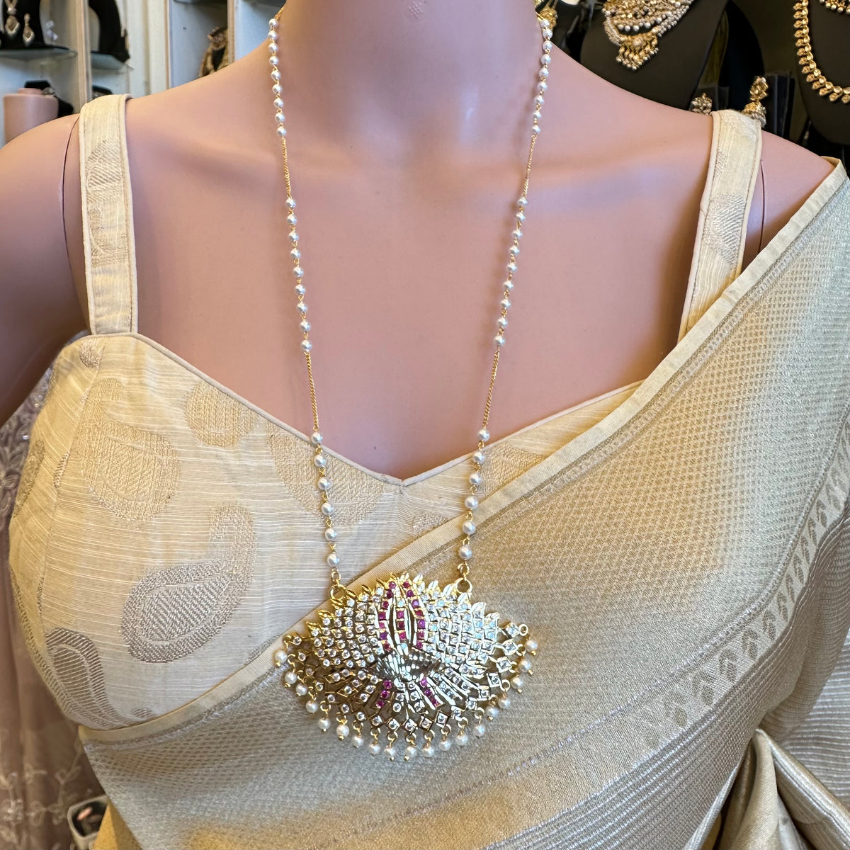 Lotus Design:
Traditional Impoun Padakkam gold-tone necklace with lotus pendant and white stone detailing.

